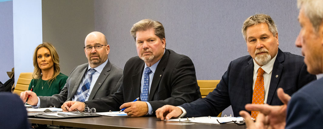 5 adults at conference room table